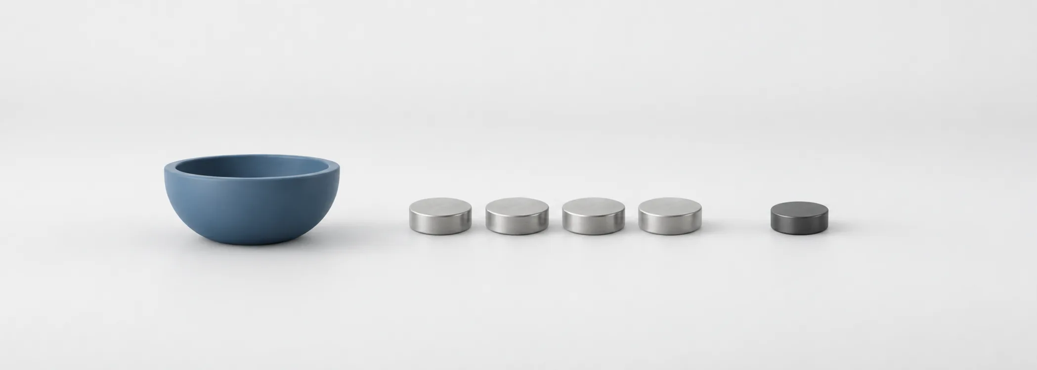 A blue earnings bowl beside equal silver discs and a smaller graphite disc, representing profit divided among shares.