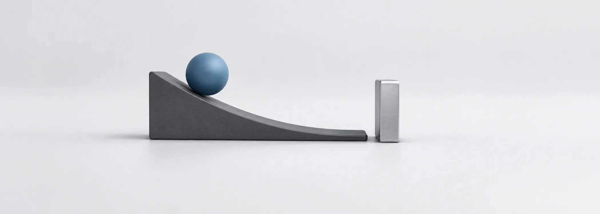 A steel-blue ball on a curved graphite ramp faces a silver barrier, suggesting momentum and an abrupt stop.