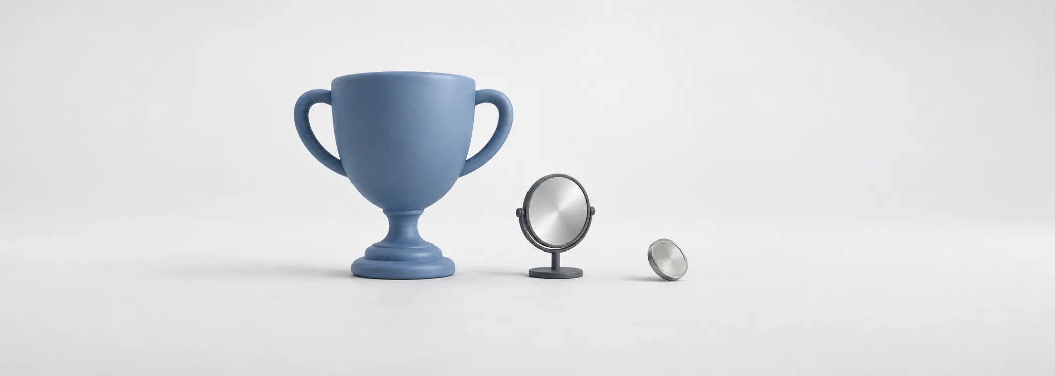 An oversized steel-blue trophy beside a small graphite mirror and silver coin, suggesting confidence outgrowing the evidence.